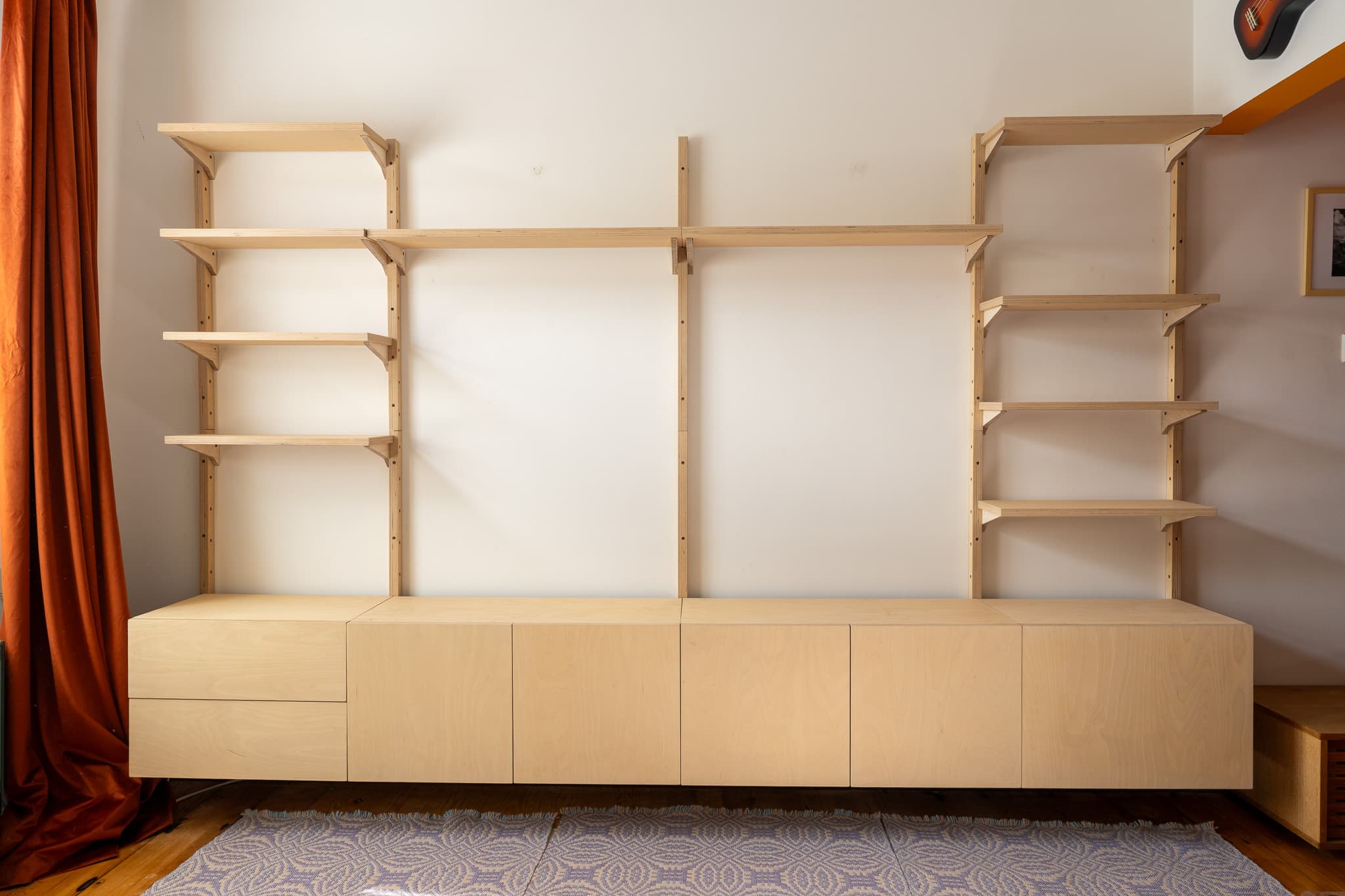 Full MESTRA wall-mounted rail and shelf system installed above birch plywood cabinets