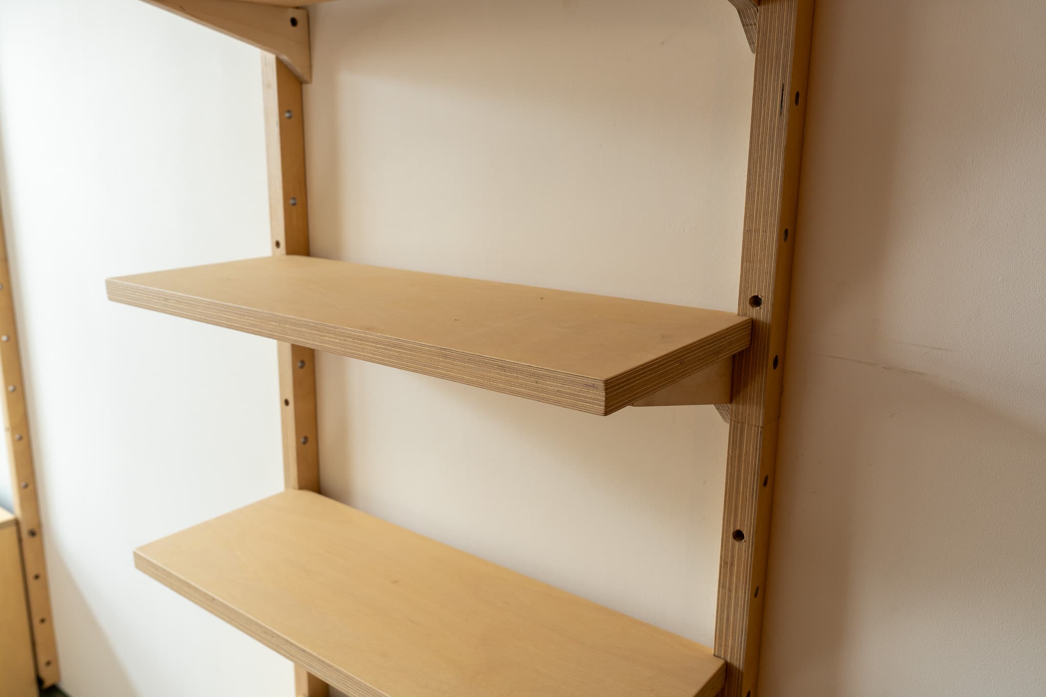 MESTRA wall-mounted shelves arranged on birch plywood rails